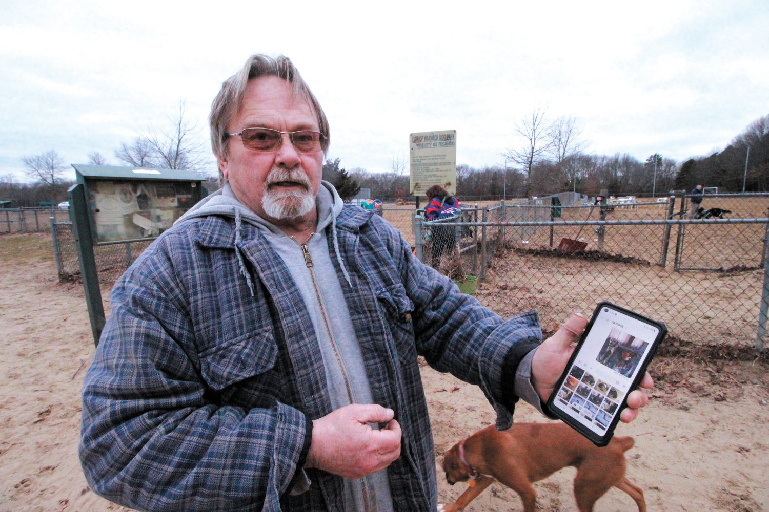 FAMILY ALBUM: Chip Hinkson, who is considered one of the dog park’s veterans, shows off photos of his two dogs, Nova and Dottie.